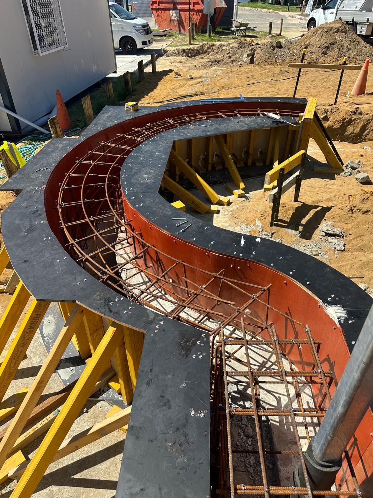 Curved concrete staircase being formed with rebar — architectural complexity